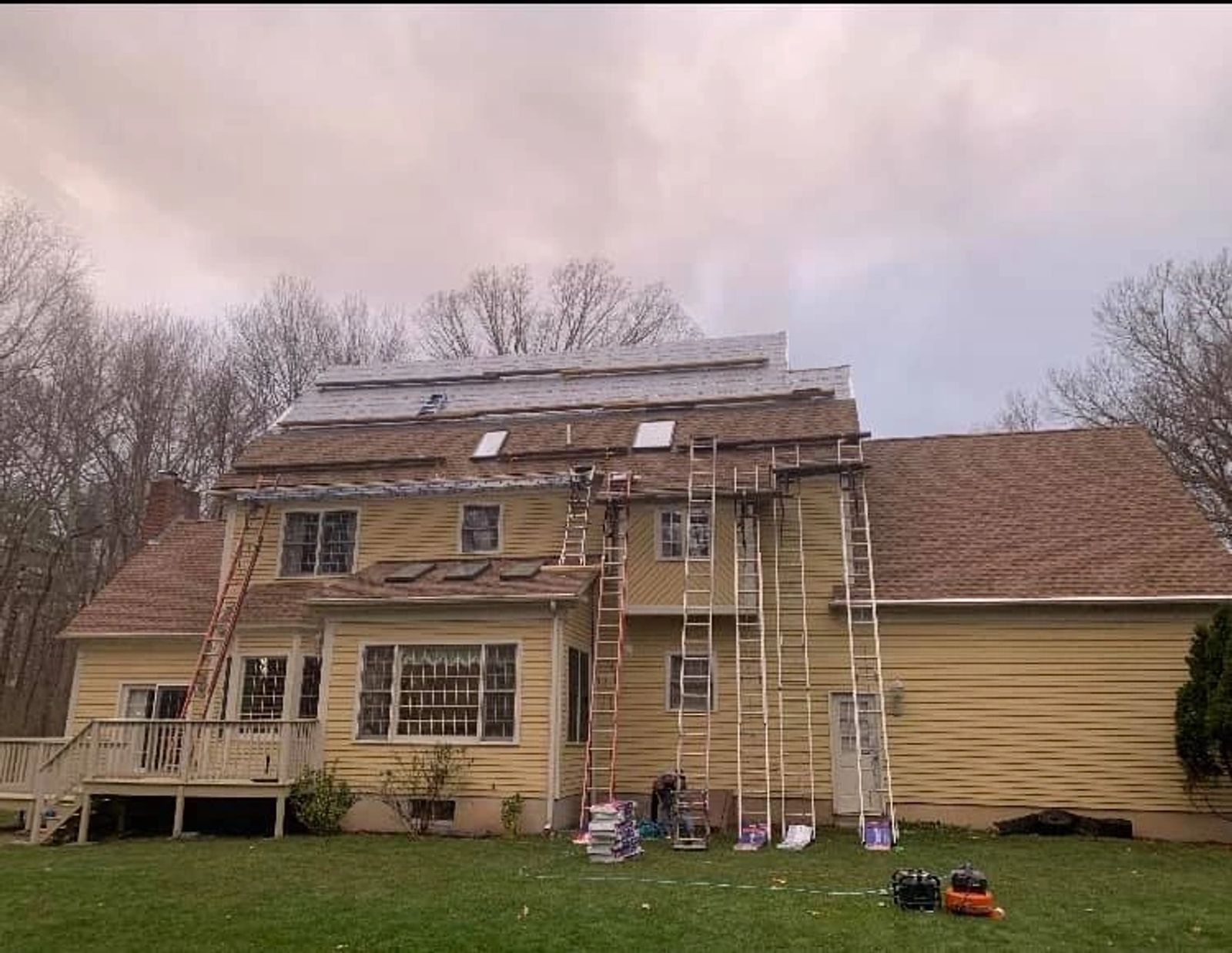 Full roofing job site setup with crew working on a residential home