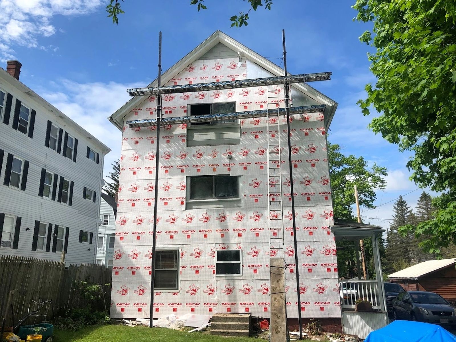 Siding installation in progress with weather-resistant underlayment